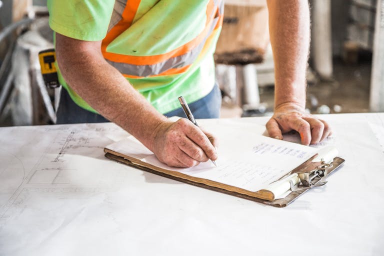 man with a clipboard doing a termite inspection
